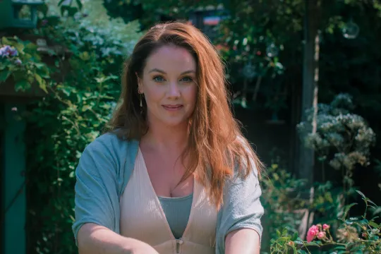 Anne Wieggers in haar tuin met bloemen