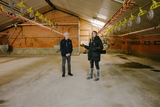 Marijn Frank met kippenboer in een lege kippenstal