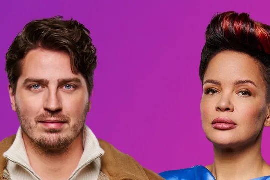 Man en vrouw staan naast elkaar voor een paarse achtergrond