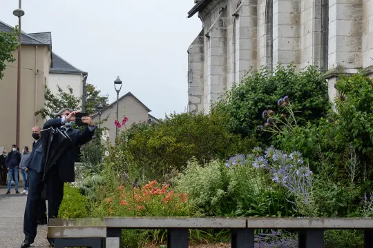 French Interior Minister Gerald Darmanin (3L) pays his respect at the Father Jacques Hamel's memorial next to the church of Saint-Etienne du Rouvray AFP