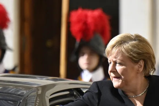German chancellor Angela Merkel puts a document on her car's trunk as she arrives at the Vatican for a meeting with the Pope on October 7, 2021.