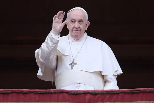 Pope Francis waves from the balcony prior to giving his Christmas Urbi et Orbi blessing to the gathered faithful in St. Peter's Square at The Vatican on December 25, 2021