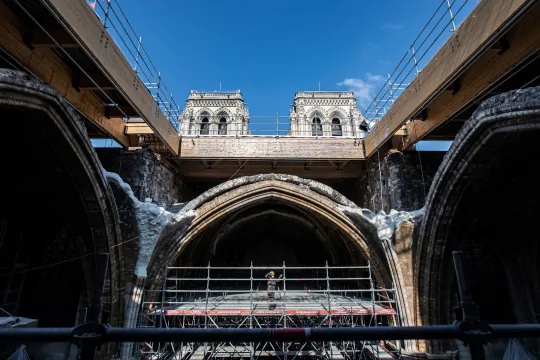 A worker stands on scaffolding under the vault of the Notre-Dame de Paris Cathedral ahead of a visit of French President two years after the blaze that made the spire collapsed and destroyed much of the roof, in Paris on April 15, 2021. The actual restoration work has yet to begin as time up until now has been spent on securing the building, and the full restoration works should begin early next year. 