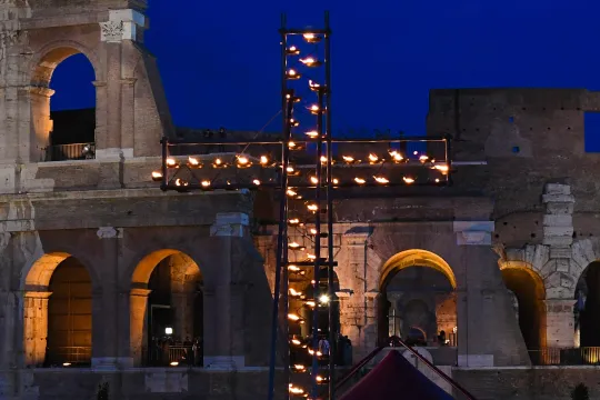 A general view shows a cross lit with candles by the Colosseum (Coliseum, Colosseo) monument for the Via Crucis (Way of the Cross) torchlight procession of Good Friday, on April 19, 2019 in Rome.