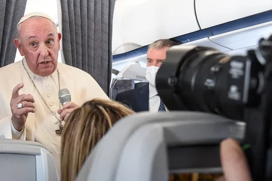 Pope Francis gives a news conference aboard the papal plane on his flight back to Rome after visiting Cyprus and Greece, on December 6, 2021. Pope Francis thanked Greece for its "gracious hospitality" as he left on December 6, 2021 following a landmark three-day visit marked by calls for better treatment of migrants in Europe
