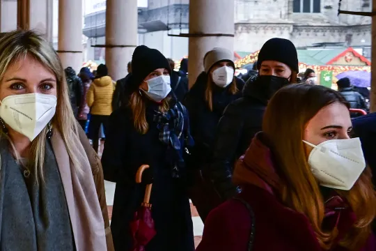 Pedestrians wearing FFP2 protective masks walk near Duomo square in the centre of Milan on January 4, 2022. The use of FFP2 masks in transport, stadiums, movie theatres, museums and sporting events is now mandatory in Italy.
