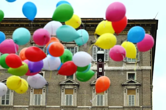 Balloons are released by a group of Christian faithful as Pope Francis (C) delivers his Sunday Angelus prayer at The Vatican on January 30, 2022. 