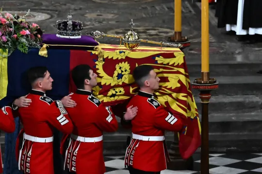 The Bearer Party of The Queen's Company, 1st Battalion Grenadier Guards carries the coffin of Queen Elizabeth II, draped in a Royal Standard and adorned with the Imperial State Crown and the Sovereign's orb and sceptre inside the Abbey at the State Funeral Service for Britain's Queen Elizabeth II, at Westminster Abbey in London on September 19, 2022. Leaders from around the world will attend the state funeral of Queen Elizabeth II. The country's longest-serving monarch, who died aged 96 after 70 years on th