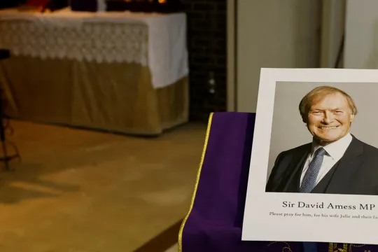 A photograph of Conservative British lawmaker David Amess, who was fatally stabbed, is pictured prior to a service at Saint Peter's Catholic Parish of Eastwood in Leigh-on-Sea in southeast England on October 15, 2021. Conservative British lawmaker David Amess was killed on Friday after being stabbed "multiple times" during an event in his local constituency in southeast England, in the second death of a UK politician while meeting voters since 2016. Local police did not name Amess but said a man had been ar