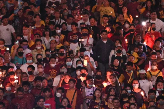 Roman Catholic devotees, some carrying miniature statues of the Black Nazarene and candles, walk along a street dubbed "walk of faith" as they celebrate the annual feast of the Black Nazarene in Manila on January 8, 2023, which devotees believed to have miraculous powers. Ted ALJIBE / AFP