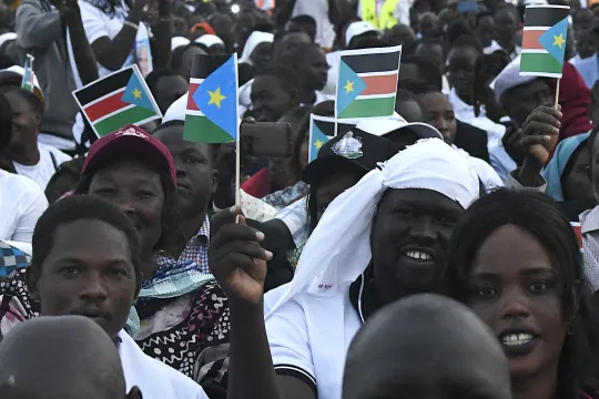 Attendees hold South Sudan flags ahead of the holy mass with Pope Francis at the John Garang Mausoleum in Juba, South Sudan, on February 5, 2023. Pope Francis wraps up his pilgrimage to South Sudan with an open-air mass on February 5, 2023 after urging its leaders to focus on bringing peace to the fragile country torn apart by violence and poverty. The three-day trip is the first papal visit to the largely Christian country since it achieved independence from Sudan in 2011 and plunged into a civil war that 