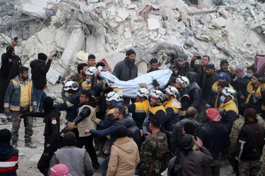 Rescuers pull a body out of the rubble of a destroyed building, as search and rescue operations continue days after a deadly earthquake hit Turkey and Syria, in the town of Jindayris, in the rebel-held part of Syria's Aleppo province, on February 10, 2023. The 7.8-magnitude quake early on February 6 has killed more than 20,000 people in Turkey and war-ravaged Syria, according to officials and medics in the two countries, flattening entire neighbourhoods. Ibrahim YASOUF / AFP