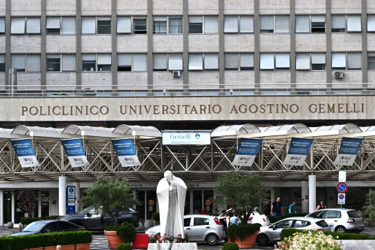 This photograph taken on June 9, 2023, shows candles and flowers layed under the statue of late Pope John Paul II at the entrance of the Rome's Gemelli hospital. Pope Francis was in a hospital in Rome for a medical check-up on June 6, according to Italian media, just over two months after he was hospitalised with bronchitis. Andreas SOLARO / AFP