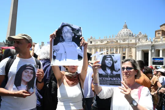 People hold placards with Emanuela Orlandi's portrait at the end of Pope's Angelus prayer in St. Peter's Square at the Vatican, on June 25, 2023. Emanuela Orlandi disappeared while returning home in Rome on June 22, 1983. VINCENZO PINTO / AFP