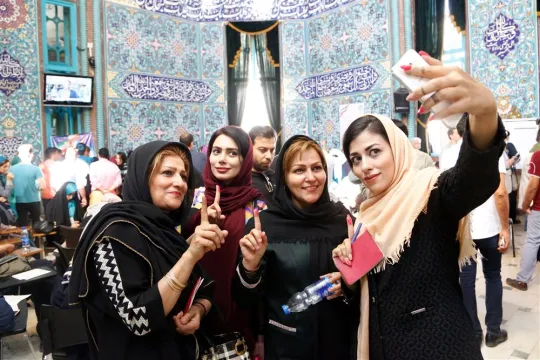 Iraanse vrouwen maken een selfie in het stemlokaal. Foto: ANP