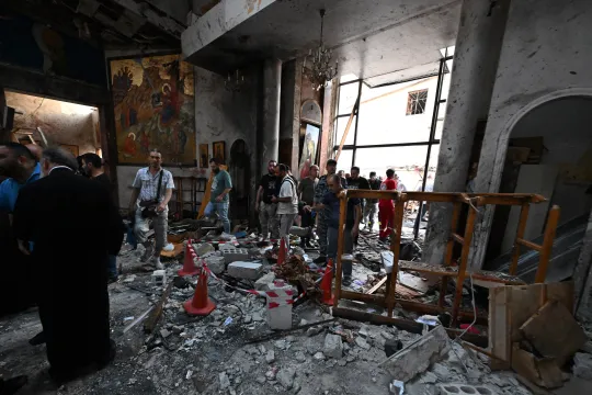 People and rescuers inspect the damage at the site of a reported suicide attack at the Saint Elias church in Damascus' Dwelaa area on June 22, 2025. Syrian state media reported a suicide attack on a Damascus church on June 22 that caused casualties, as AFP correspondents at the scene saw first responders transporting people from the site. LOUAI BESHARA / AFP