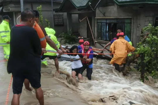 This handout photo taken on September 26, 2025 and received through the Facebook page of Palanas Municipal Disaster Risk and Reduction Management Office (MDRRMO) shows rescuers evacuating residents from their flooded house during Severe Tropical Storm Bualoi in Palanas, Masbate province. The Philippines evacuated hundreds of thousands of people and confirmed at least three deaths on September 26 as it faced yet another tropical storm, days after it was battered by deadly Super Typhoon Ragasa. Handout / PALA
