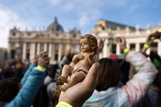 A faithful holds a baby Jesus figurine to receive a blessing as Pope Leo XIV leads the Angelus prayer, the traditional Sunday prayer, from the window of his office overlooking Saint Peter's Square, Vatican City, 21 December 2025. EPA/ANGELO CARCONI