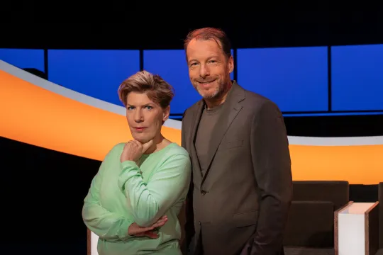 Man en vrouw lachend in een studio