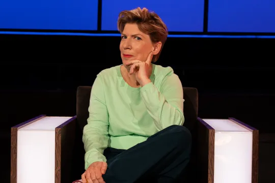 Vrouw zit in een stoel met haar hand onder haar hoofd