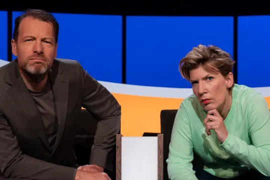 Man en vrouw in studio kijken serieus