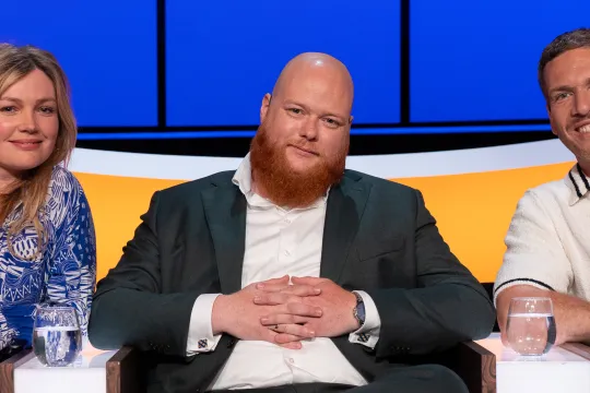 Twee mannen en vrouw in studiostoelen