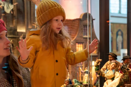 Meisje en vrouw kijken naar kerststal