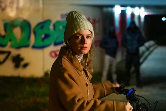 een vrouw op een fiets bij een tunnel