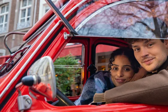 twee mensen in een rode auto