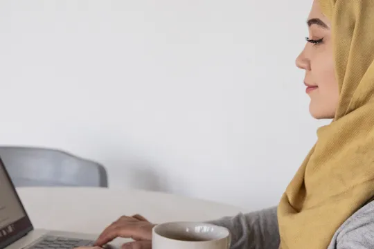 Meisje aan een tafeltje met een laptop