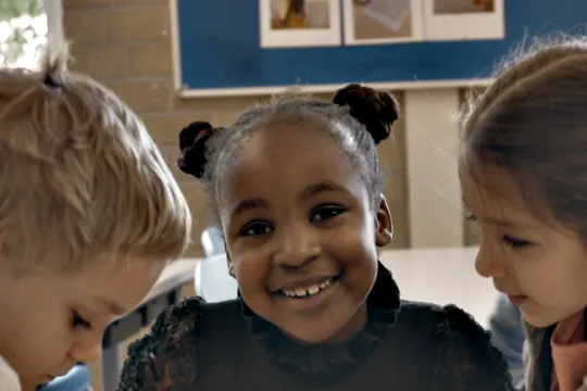 Nyah Nameh met een pop in de klas