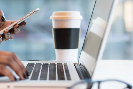Vrouw bezig met laptop en telefoon