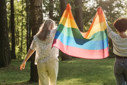 Twee vrouwen met de regenboogvlag