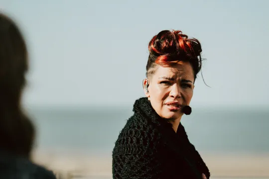 Vrouw kijkt serieus op het strand