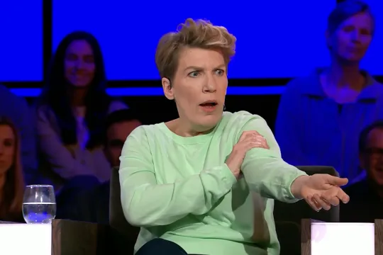 Vrouw met groene trui houdt haar arm vast