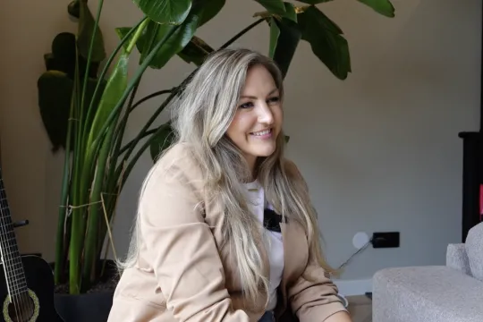 Lachende blonde vrouw in een woonkamer