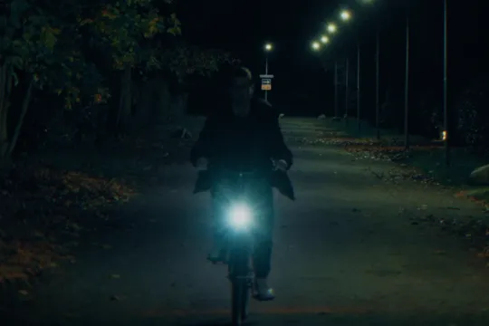 Een man op een fiets in het donker