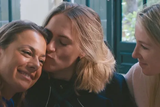 drie vrouwen geven elkaar een knuffel op de bank