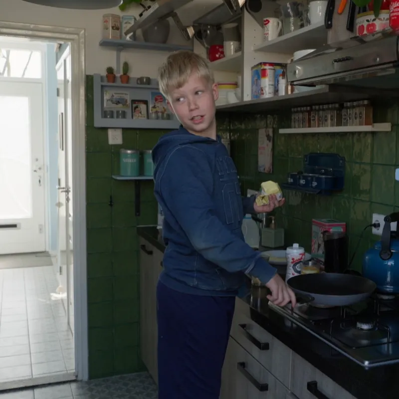 Een jongen achter het fornuis