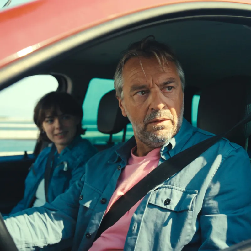 Man en kind in auto met gordel om