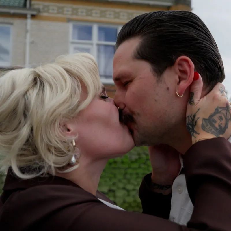 Blonde vrouw en man met zwart haar kussen