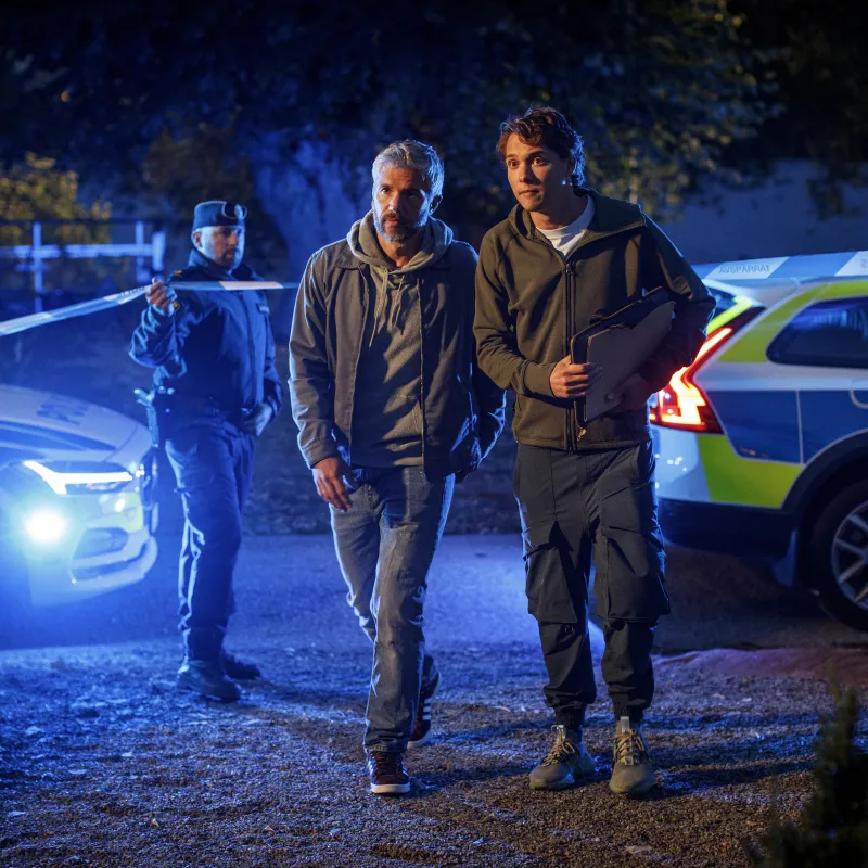 2 mannen lopen een crime scene op. 