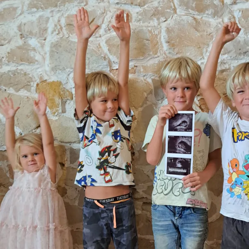 De kinderen van de familie Verleg juichend met een echofoto