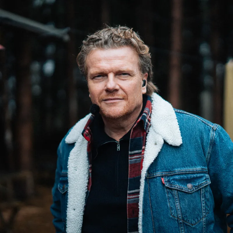 Man met spijkerjack en microfoon