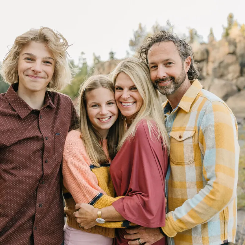 Een familie met puberende kinderen, lachend in de camera kijkend