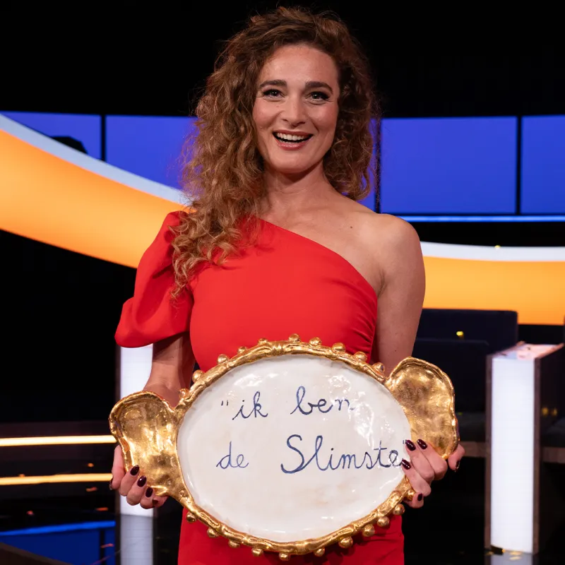 Lachende vrouw in rode jurk met schaal