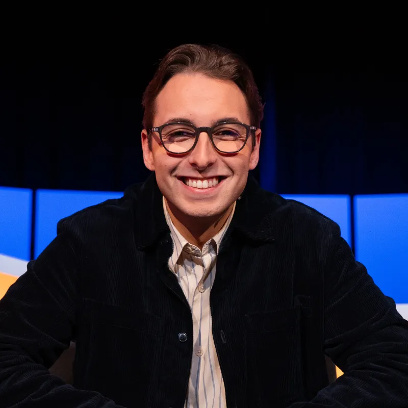 Jongen met bril en zwart vest in de studio