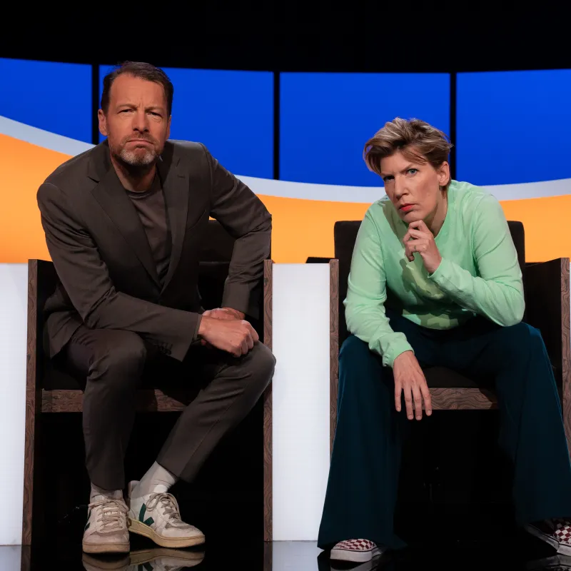 Man en vrouw in studio kijken serieus