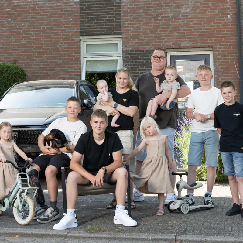 De familie De Lange uit Een huis vol poseert voor een huis