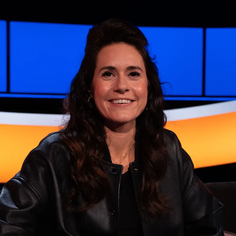 Lachende vrouw met zwart haar en zwarte jack